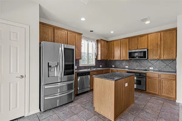 a kitchen with granite countertop a sink and a refrigerator