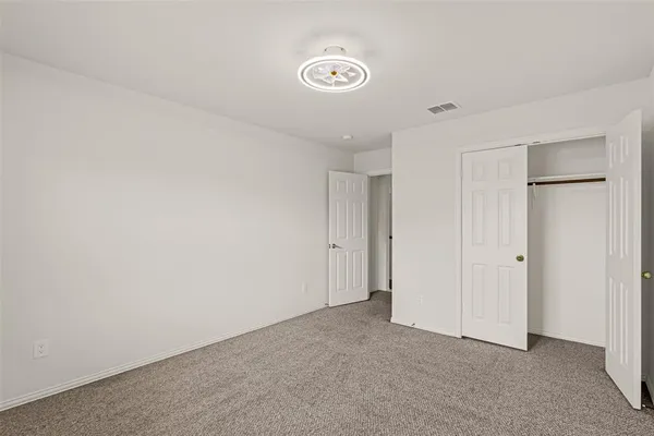 an empty room with chandelier fan
