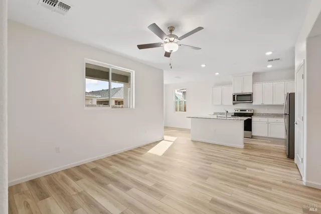 a view of kitchen with granite countertop cabinets and refrigerator