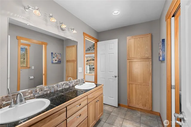 a bathroom with a granite countertop sink a mirror and a shower