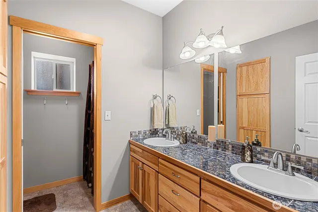 a bathroom with a granite countertop sink and a mirror