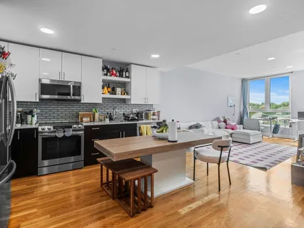 a kitchen with stainless steel appliances granite countertop a refrigerator a stove a sink and a microwave