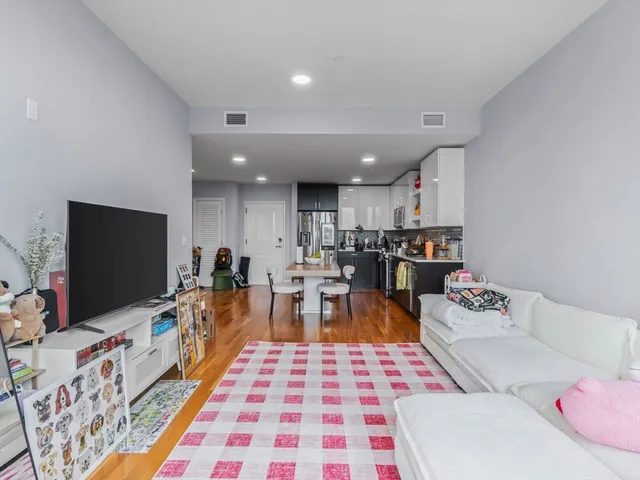 a kitchen with stainless steel appliances granite countertop wooden floor a refrigerator and a stove top oven