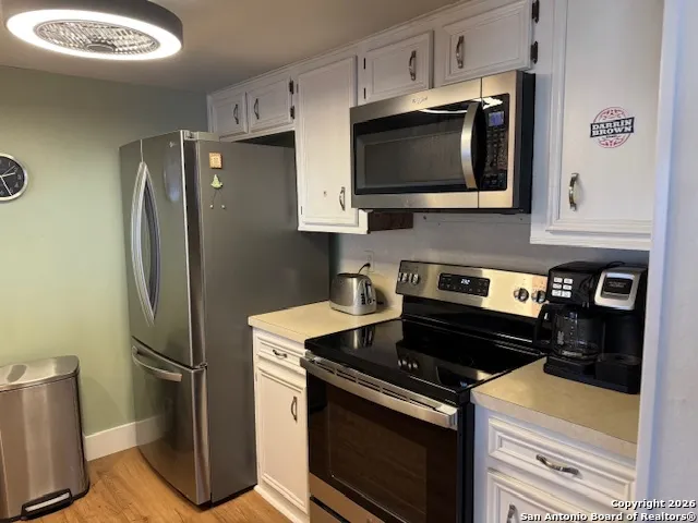 a kitchen with stainless steel appliances a stove a microwave and cabinets