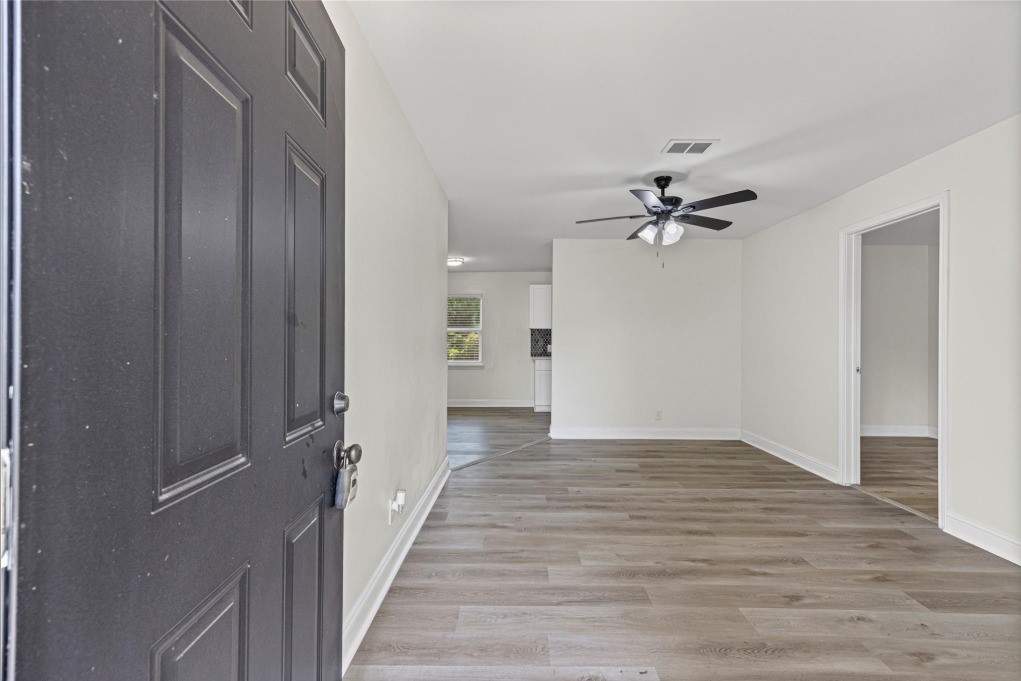 6410 Hartwick Road Houston, TX 77016 - Photo 2 of 16 a view of a hallway with wooden floor and a chandelier