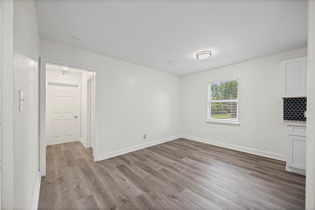 6410 Hartwick Road Houston, TX 77016 - Photo 4 of 16 an empty room with wooden floor and windows
