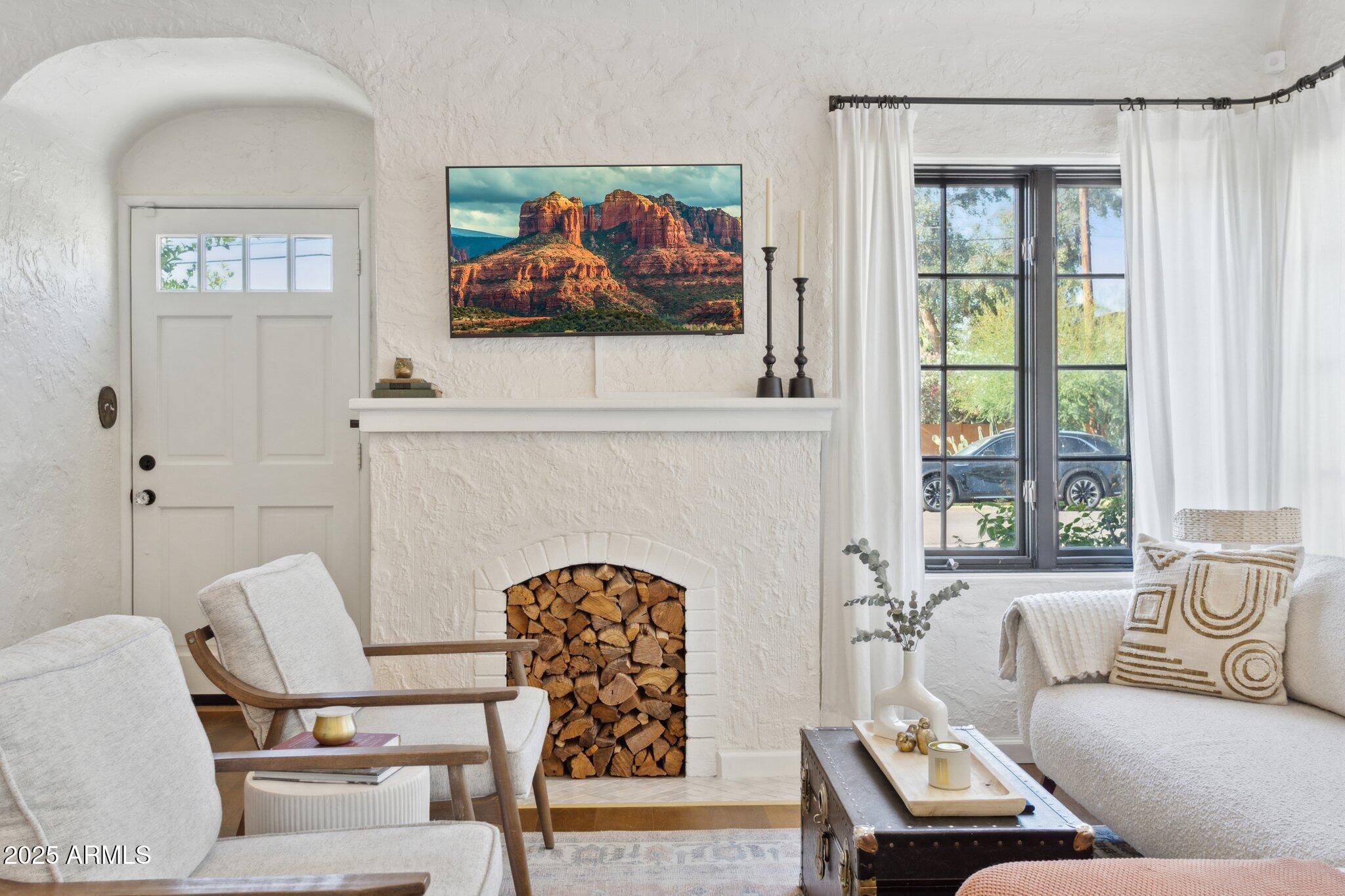 1111 East Coronado Road Phoenix, AZ 85006 - Photo 8 of 77 a living room with furniture a fireplace and a painting on the wall