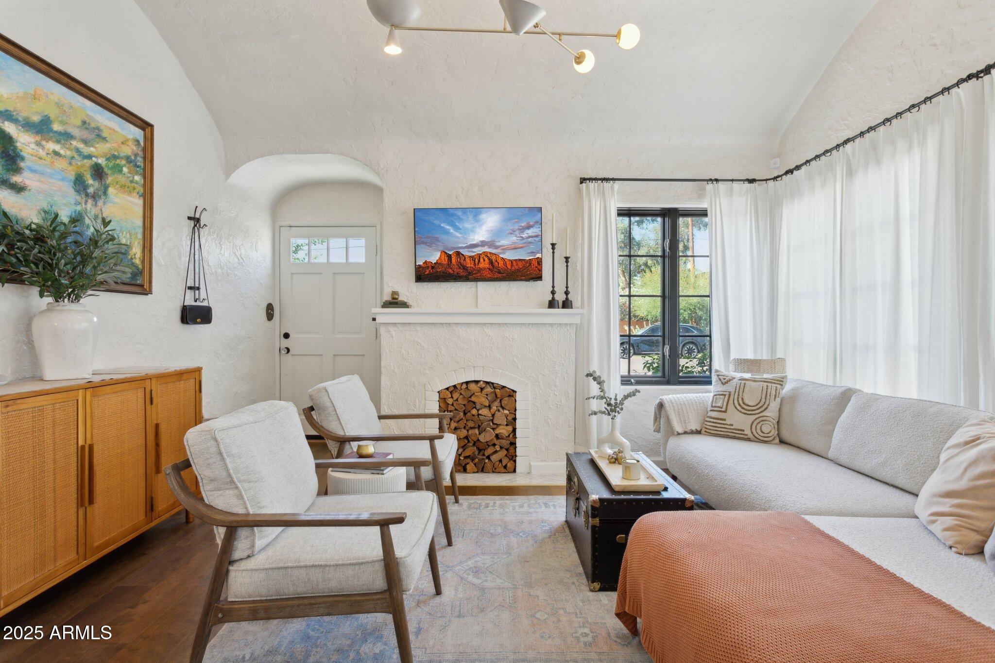1111 East Coronado Road Phoenix, AZ 85006 - Photo 5 of 77 a living room with furniture a fireplace and a large window
