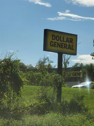 a street sign that is sitting in the grass next to a road