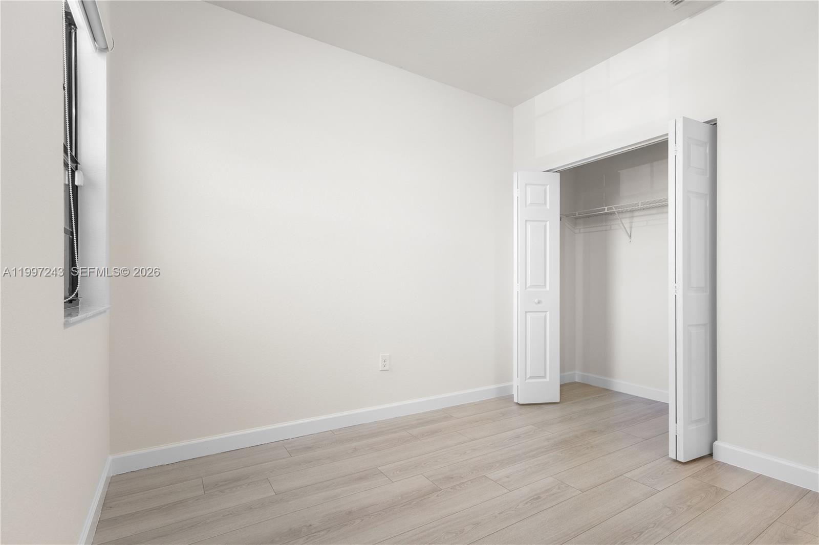 15075 Southwest 113th Terrace Miami, FL 33196 - Photo 26 of 36 a view of an empty room with wooden floor & closet