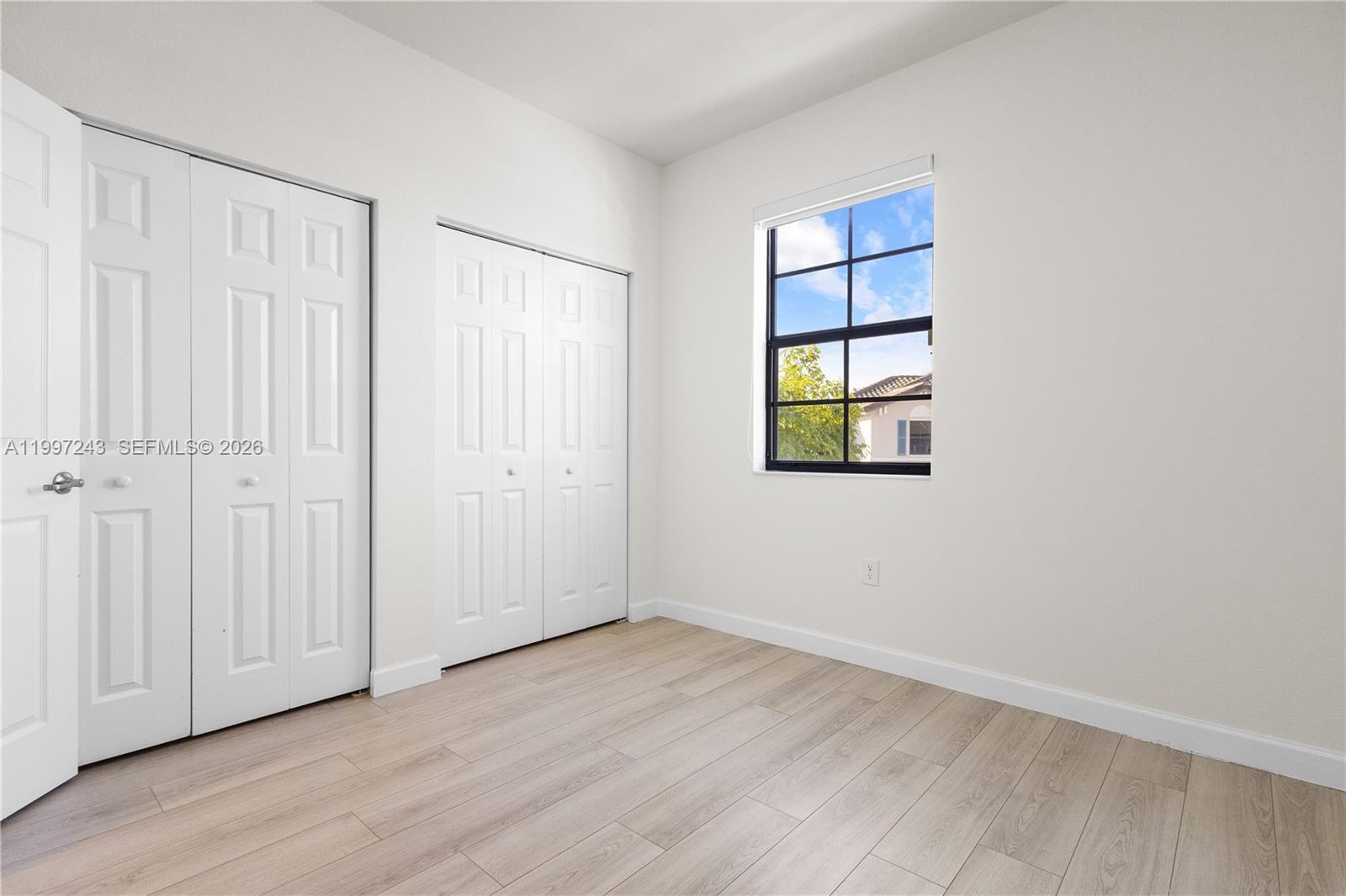 15075 Southwest 113th Terrace Miami, FL 33196 - Photo 30 of 36 an empty room with wooden floor and windows