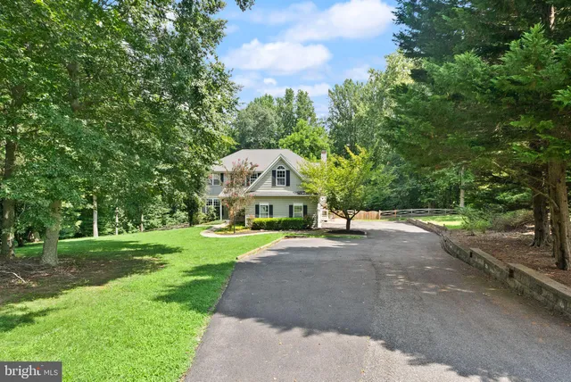 a view of a house next to a yard with big trees