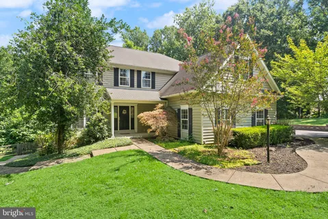 a front view of a house with a yard and trees