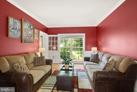 a view of a dining room with furniture a chandelier and wooden floor