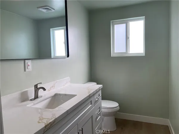 an empty room with wooden floor and window