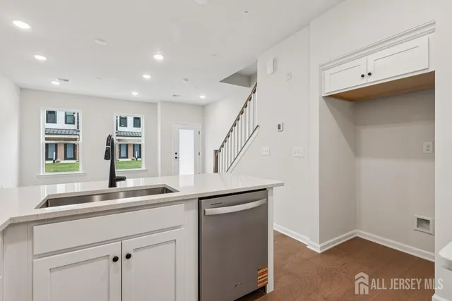 a kitchen with a sink and wooden floor