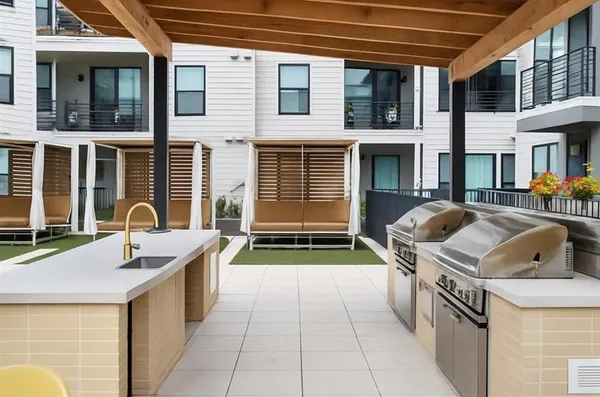 a backyard of a house with barbeque oven and furniture