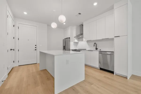 a kitchen with cabinets and white stainless steel appliances