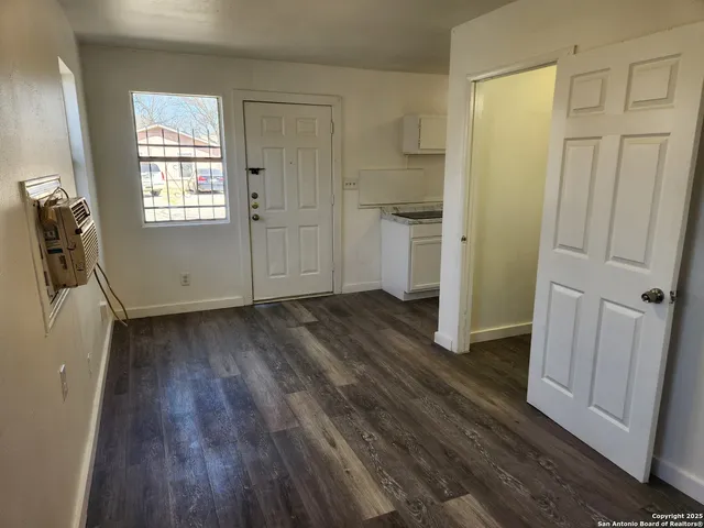 an empty room with wooden floor and a window