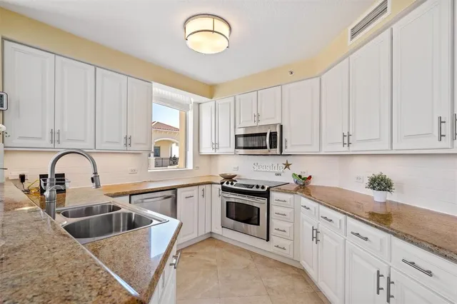 a kitchen with stainless steel appliances granite countertop a sink and cabinets