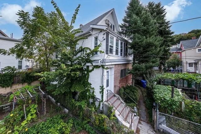 a front view of a house with a garden and plants