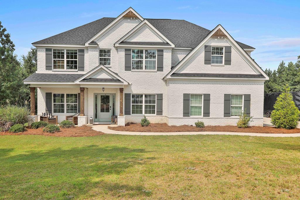 a front view of a house with a yard and seating space