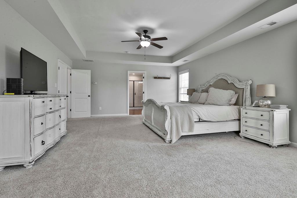 169 Hart Ridge Court Fortson, GA 31808 - Photo 31 of 50 a spacious bedroom with a bed and a flat screen tv