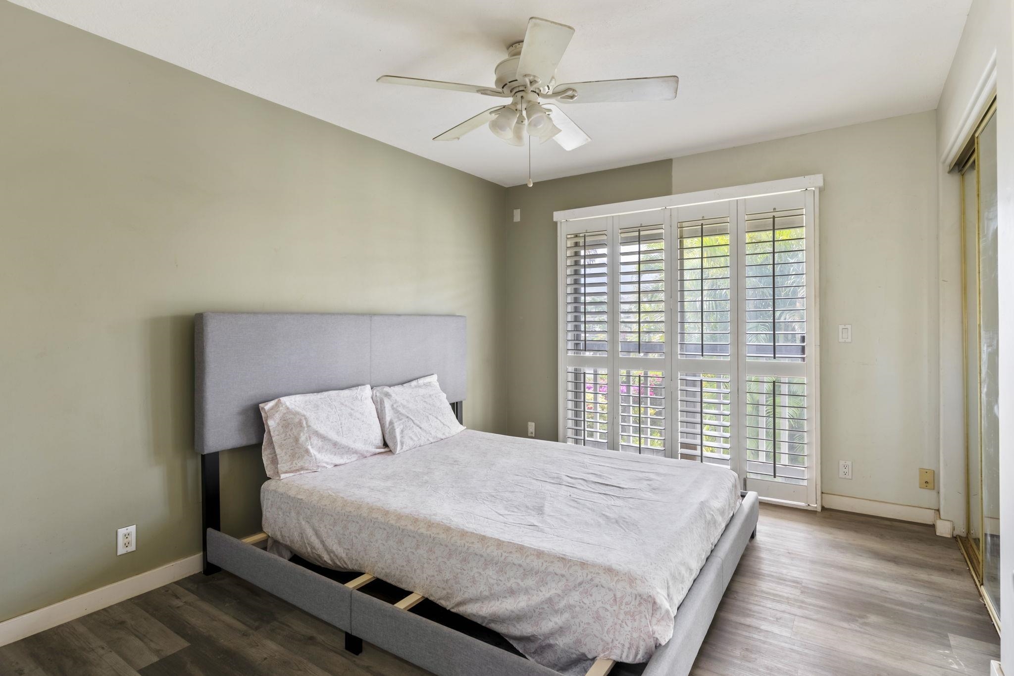 2058 Kanoe Street, Unit 2C Kihei, HI 96753 - Photo 6 of 27 a bedroom with a large bed and a chandelier