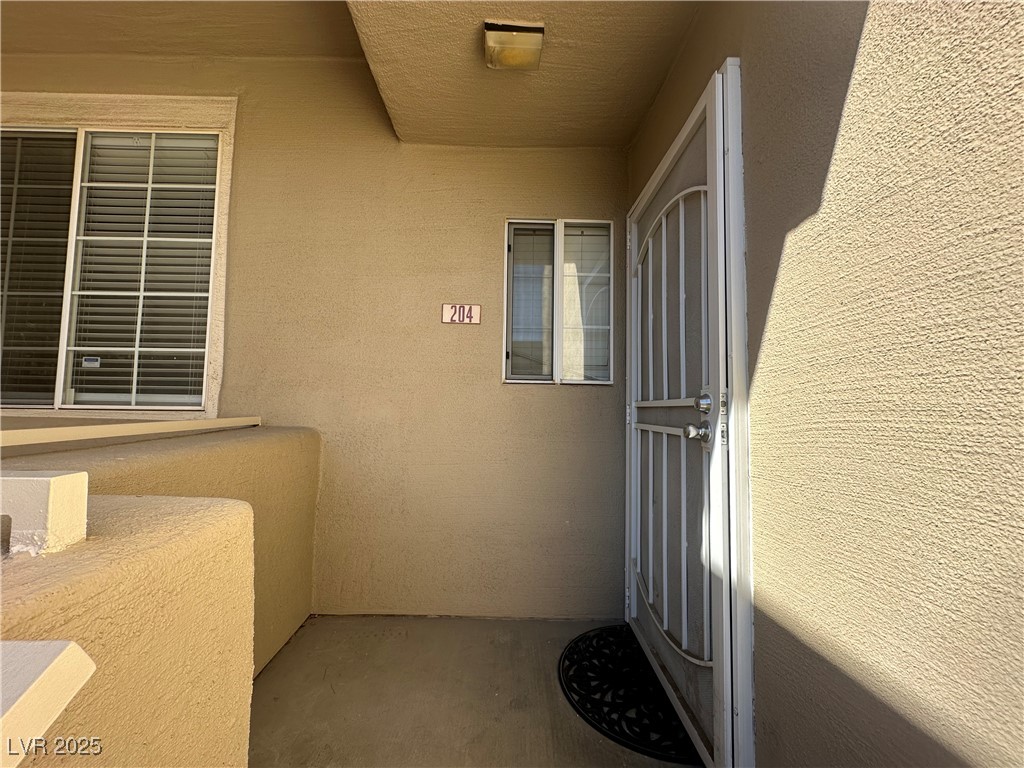 1908 High Valley Court, Unit 204 Las Vegas, NV 89128 - Photo 3 of 18 View of exterior entry featuring stucco siding