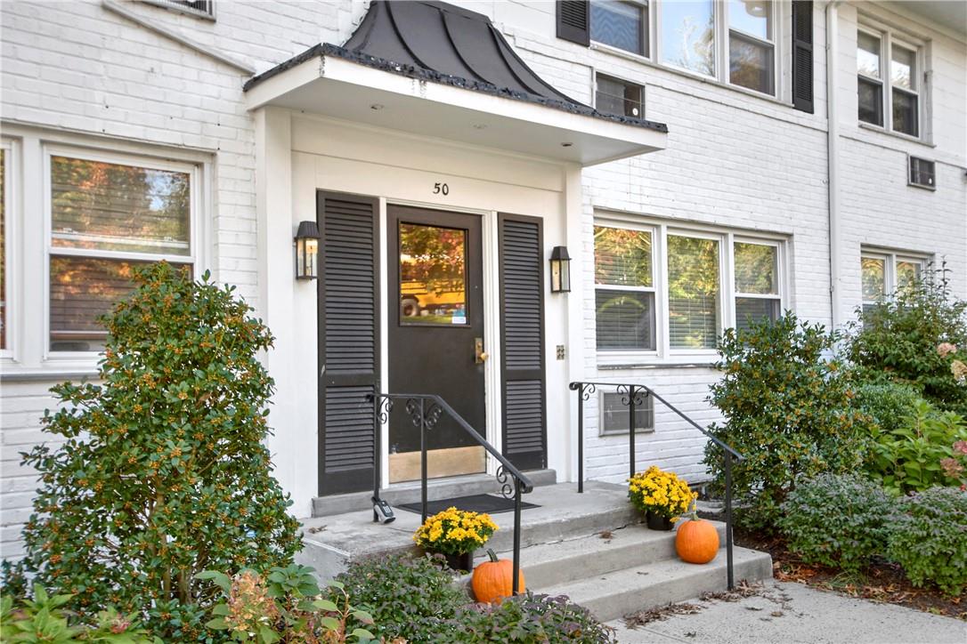 50 North Ridge Street, Unit C Rye Brook, NY 10573 - Photo 1 of 1 front view of a brick house with potted plants and a table and chairs