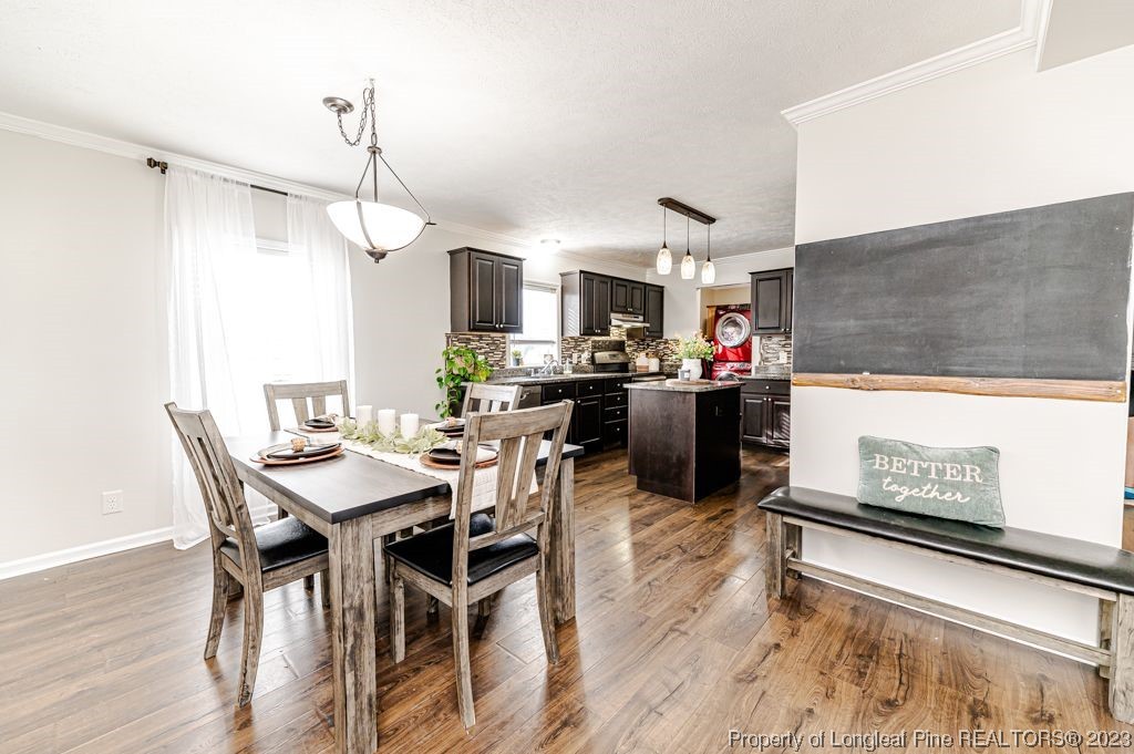 125 Wright Road Vass, NC 28394 - Photo 13 of 48 a kitchen with stainless steel appliances kitchen island granite countertop a table chairs and a refrigerator