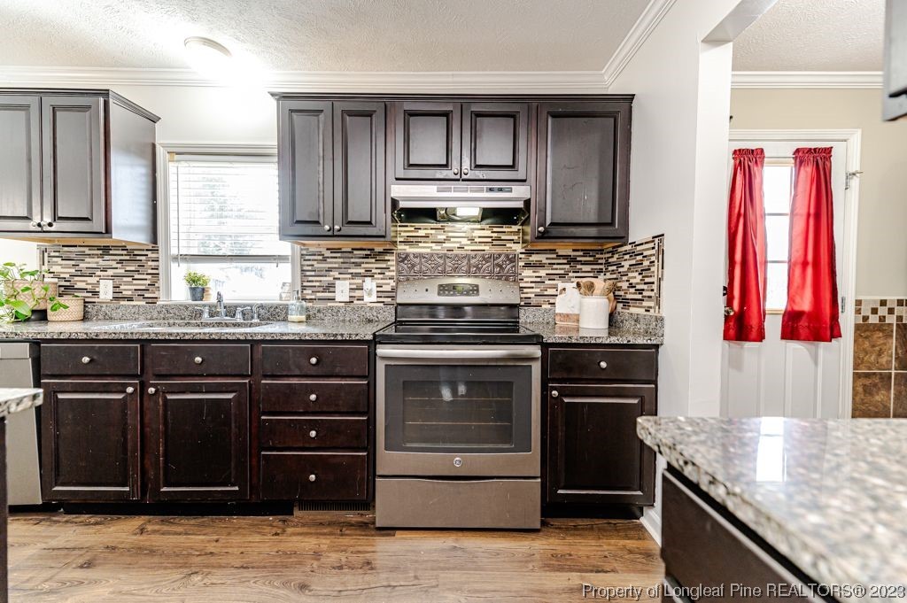 125 Wright Road Vass, NC 28394 - Photo 21 of 48 a kitchen with stainless steel appliances granite countertop a stove sink and cabinets