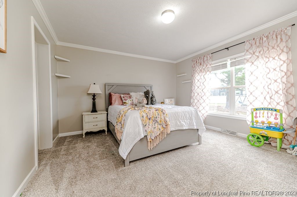 125 Wright Road Vass, NC 28394 - Photo 37 of 48 a bedroom with a bed a table and a window