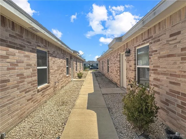a view of a pathway along with brick wall