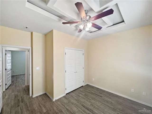 wooden floor in an empty room with a fan