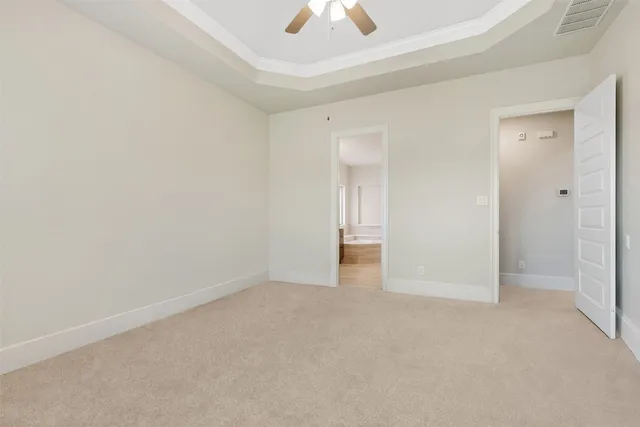 a view of an empty room and a chandelier fan