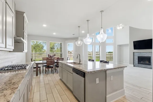 a kitchen with stainless steel appliances granite countertop a stove and a wooden floors
