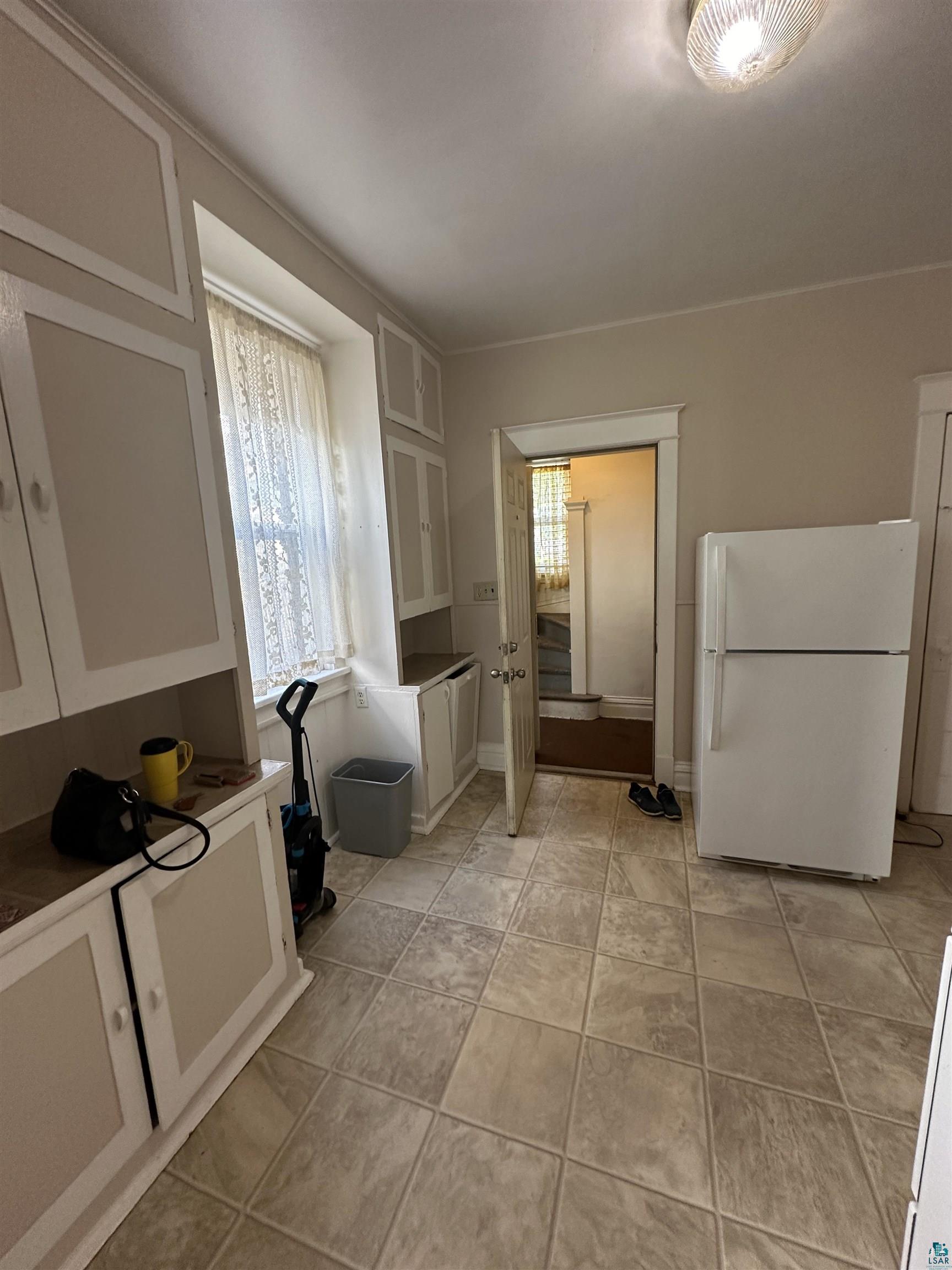2119 West 3rd Street Duluth, MN 55806 - Photo 12 of 32 Kitchen featuring a healthy amount of sunlight, white cabinetry, and white refrigerator