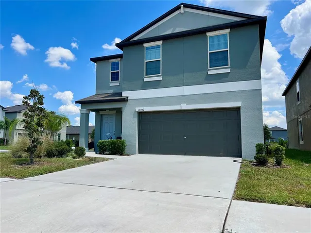 a front view of a house with a yard and garage