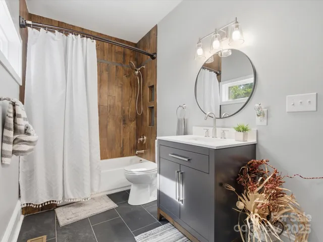 a spacious bedroom with a bed a couch and a flat screen tv