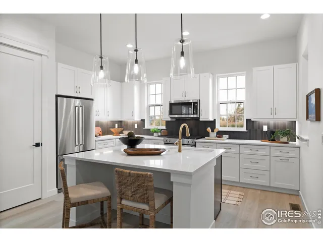 a kitchen with kitchen island a sink stove and white cabinets