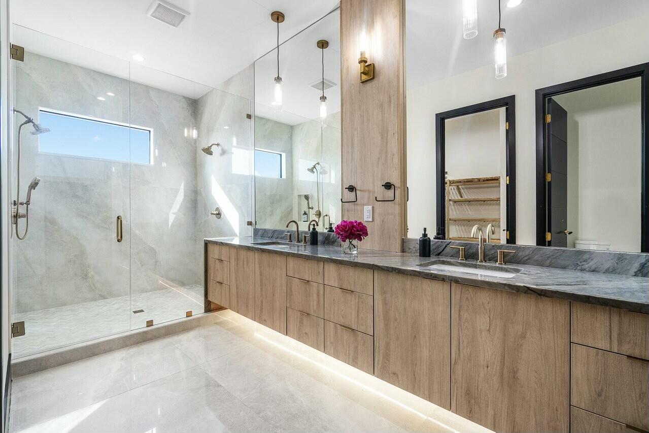 13480 Highway 1 Juno Beach, FL 33408 - Photo 28 of 90 a bathroom with a granite countertop sink mirror and a shower