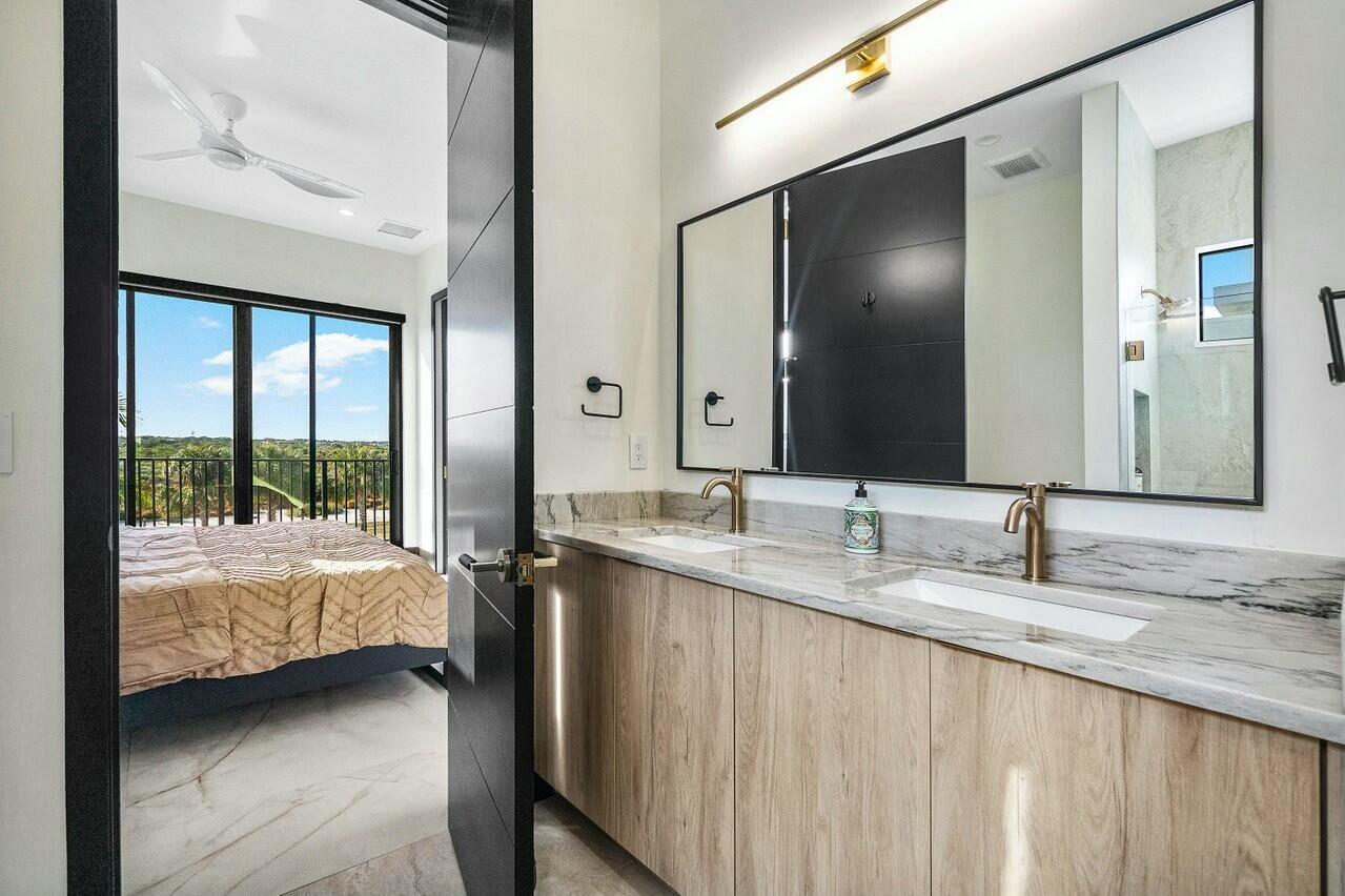 13480 Highway 1 Juno Beach, FL 33408 - Photo 48 of 90 a en suite bathroom with a granite countertop double vanity and a large mirror