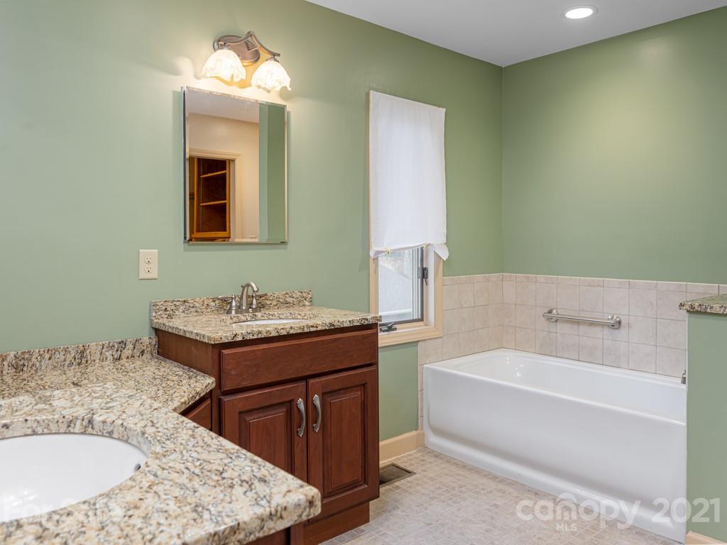 11 Hilltop Road Asheville, NC 28803 - Photo 23 of 42 a bathroom with a tub sink and mirror