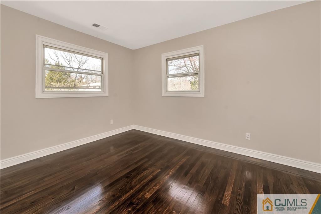 10 Jean Road East Brunswick, NJ 08816 - Photo 14 of 21 a view of an empty room with wooden floor and a window