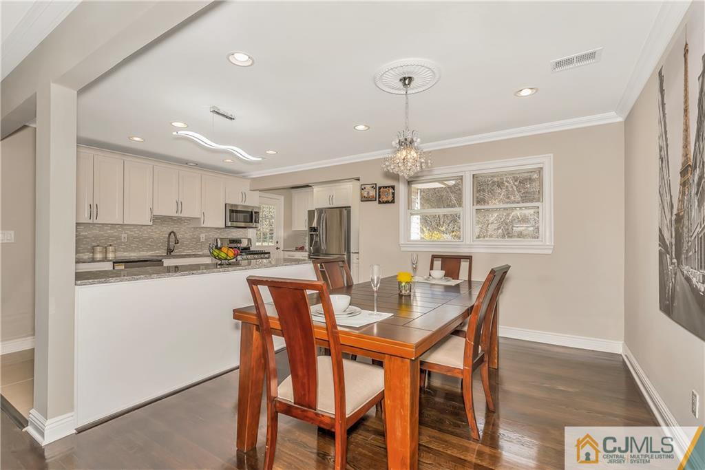 10 Jean Road East Brunswick, NJ 08816 - Photo 7 of 21 a kitchen with stainless steel appliances kitchen island granite countertop a dining table chairs and a refrigerator