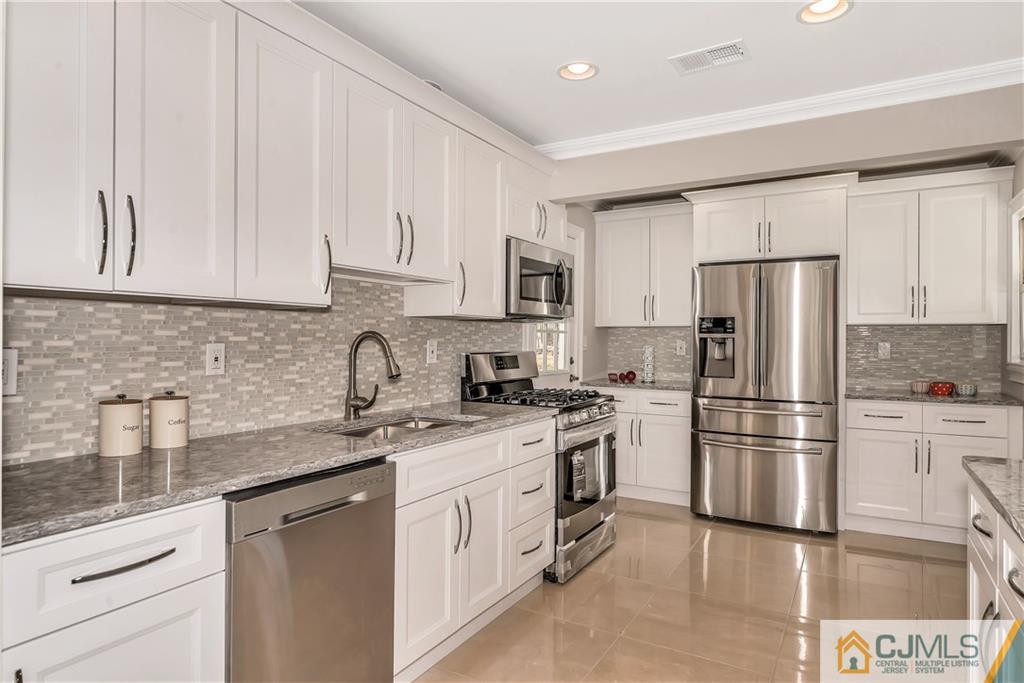 10 Jean Road East Brunswick, NJ 08816 - Photo 8 of 21 a kitchen with stainless steel appliances granite countertop a refrigerator sink and white cabinets