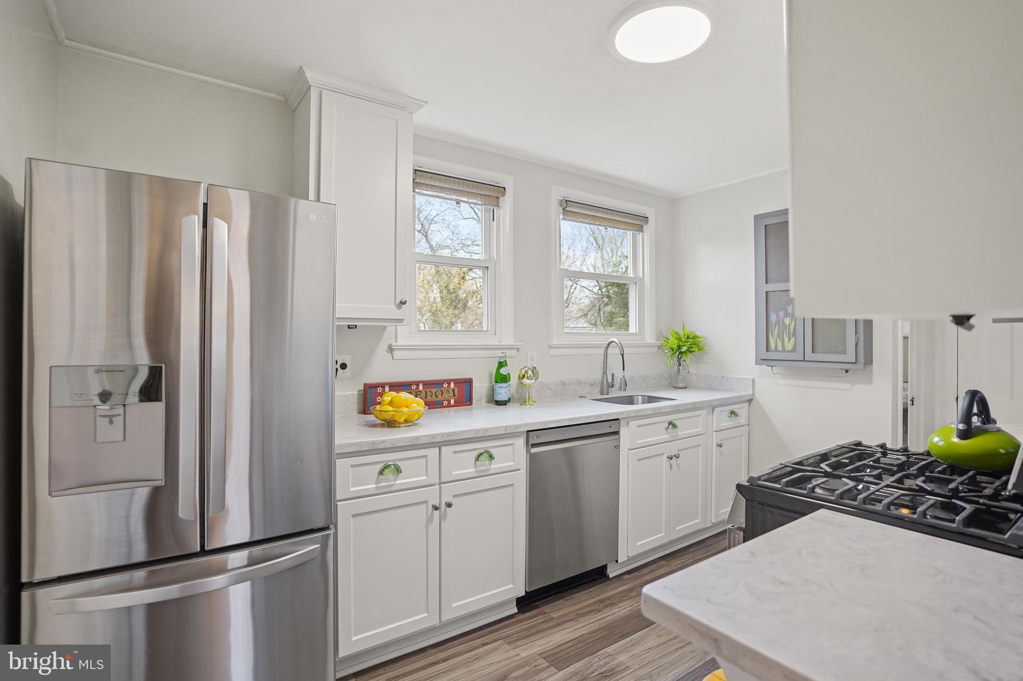 8907 Flower Avenue Silver Spring, MD 20901 - Photo 6 of 20 a kitchen with stainless steel appliances a refrigerator sink and white cabinets