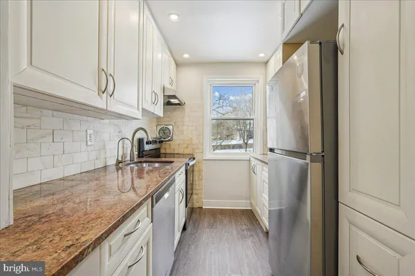 a view of kitchen with white cabinets