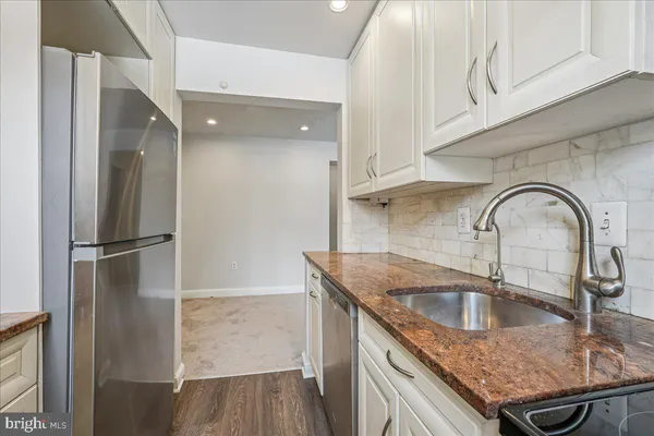 a kitchen with stainless steel appliances granite countertop a sink a stove and cabinets